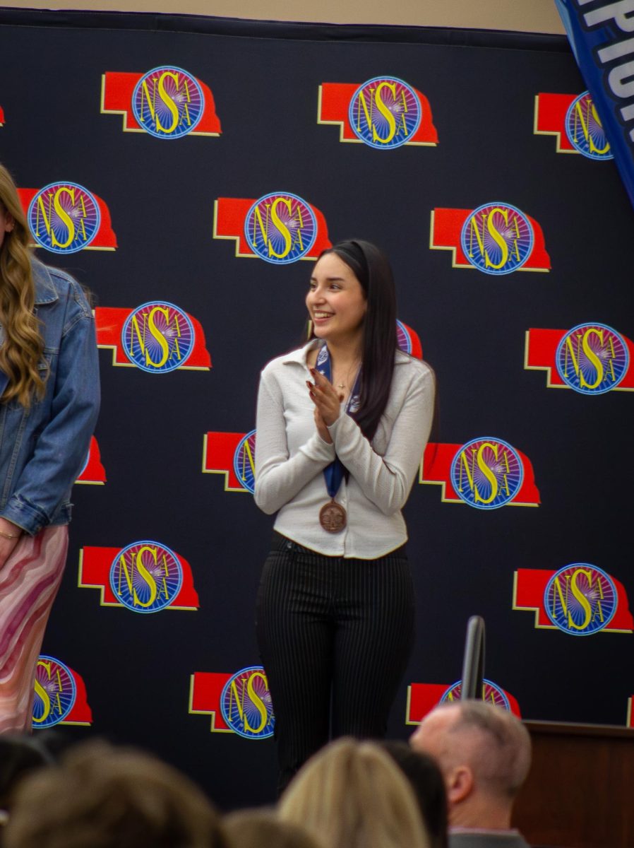 As other winners are being awarded for editorial writing, senior Cassandra Santillan claps for them. “My favorite moments from NSAA this year are definitely the bus rides to and from Northeast,” Santillan said, “as well as watching all of the medalists receive their recognition! I felt such an immense amount of pride in their accomplishments and knowing it was my last year made me feel certain us seniors were leaving the department in good hands.”